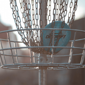 A blue disc sits in a disc golf basket.