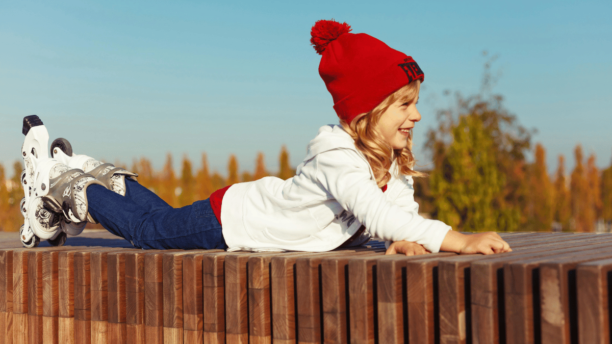 A girl rests on a bench while confident she's wearing the best kids rollerblades for her age and ability.