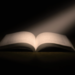 An open book with a spotlight on it.