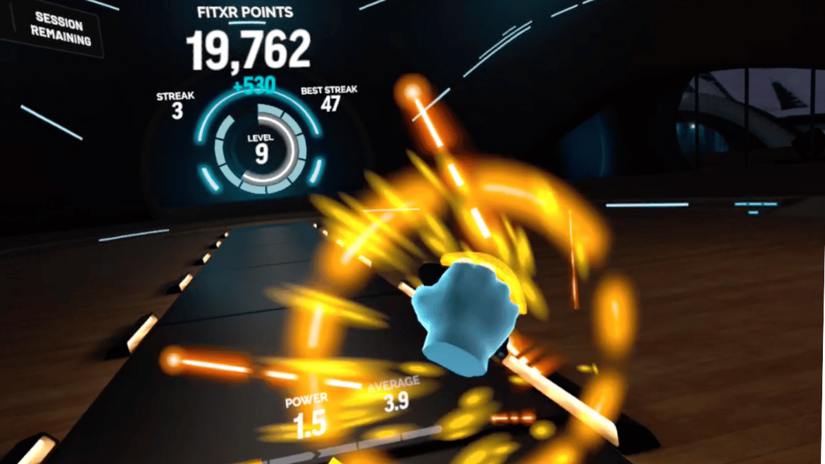 A blue hand punches at an exploding orb in the VR fitness app called FitXR.