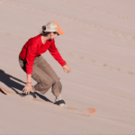 A woman sandboarding.