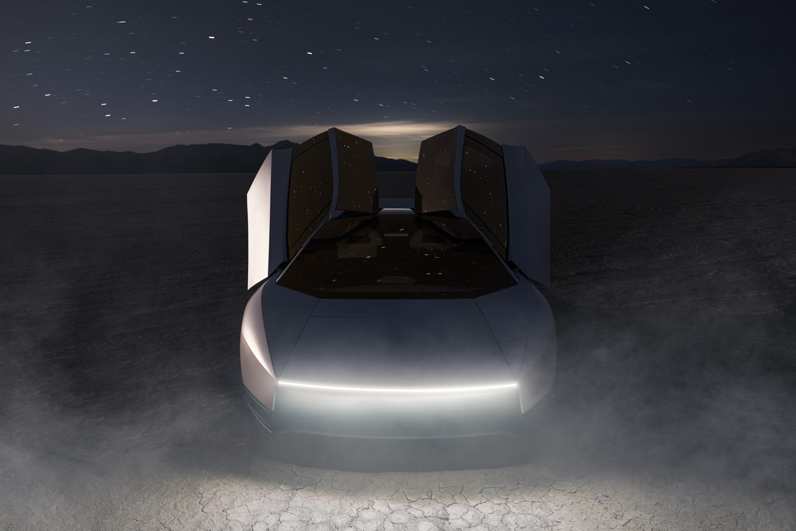 Headlights on and doors open, the Roadster faces the camera at night