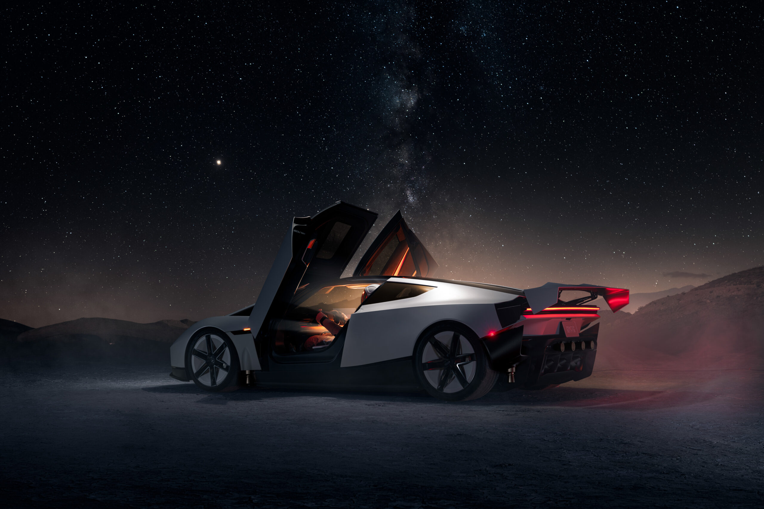Doors open and interior glowing, the Roadster sits under the stars