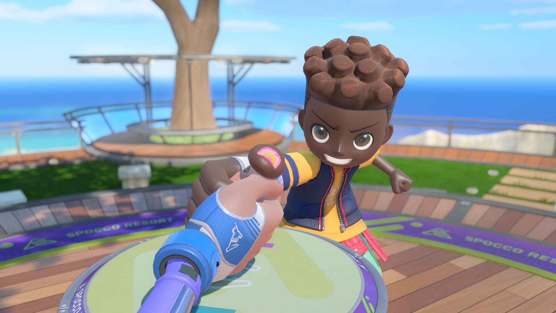 First person view of a Thumb Wrestling match in Nintendo Switch Sports Resort, with a smiling cartoon opponent leaning over a round wooden table on a seaside deck