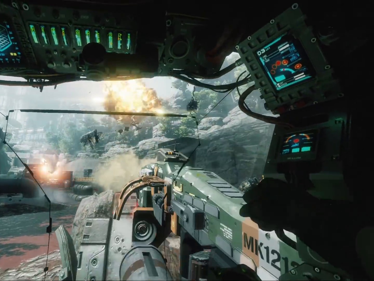 View from inside a Titan cockpit with glowing screens on both sides as the robot's huge arm fires at an explosion in a jungle
