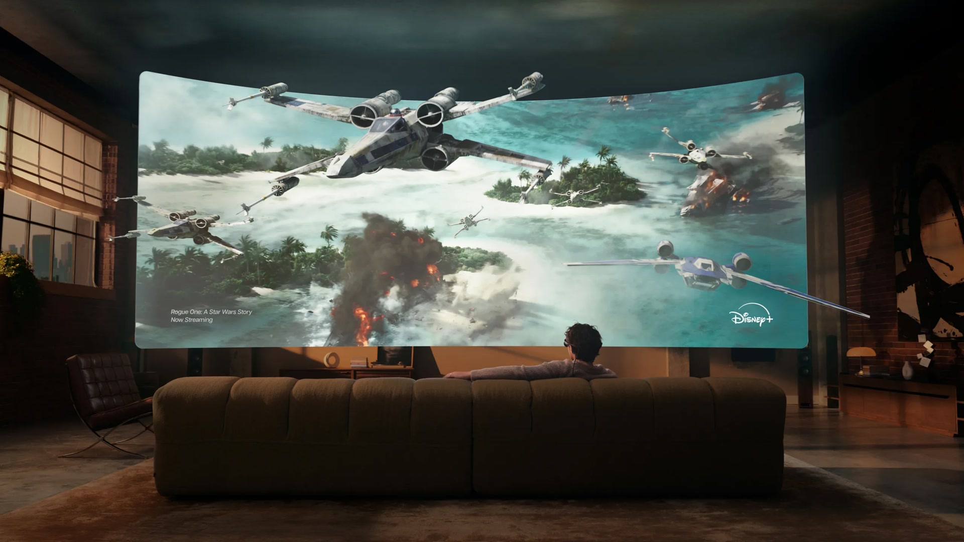 Person on a couch in a dim loft watching a huge virtual cinema screen with Meta VR Glasses